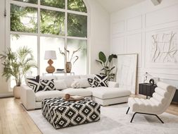 DFS Calix right hand facing large chaise end sofa in in ivory boucle, Calix pattern large square footstool, and Calix ripple accent chair in ivory boucle